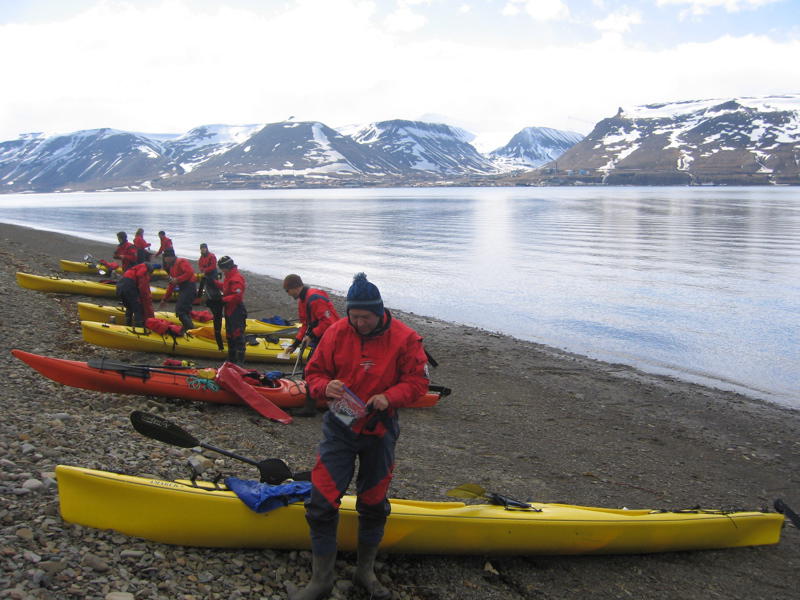 Ankunft mit dem Kajak auf der Longyearbyen gegenueberliegenden Seite des Adventfjord - Trockenanzuege und Spritzschutz schuetzen waehrend der Fahr